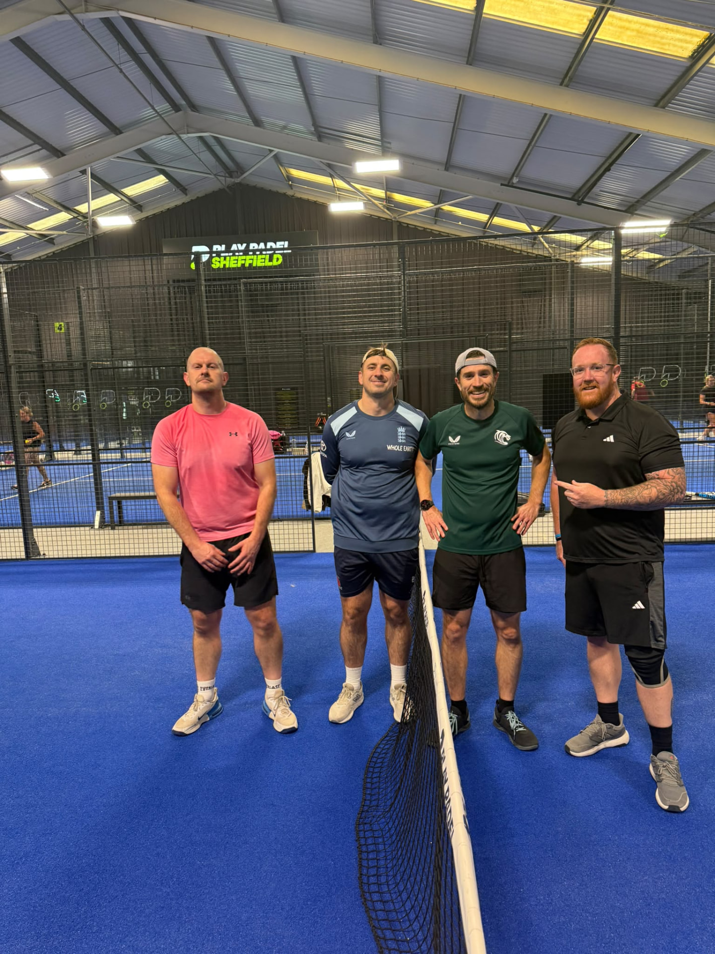 Four members either side of the net on the padel court