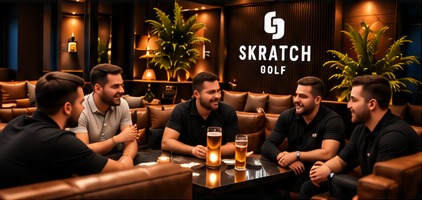 A group of men laughing over drinks on the leather sofas in the lounge
