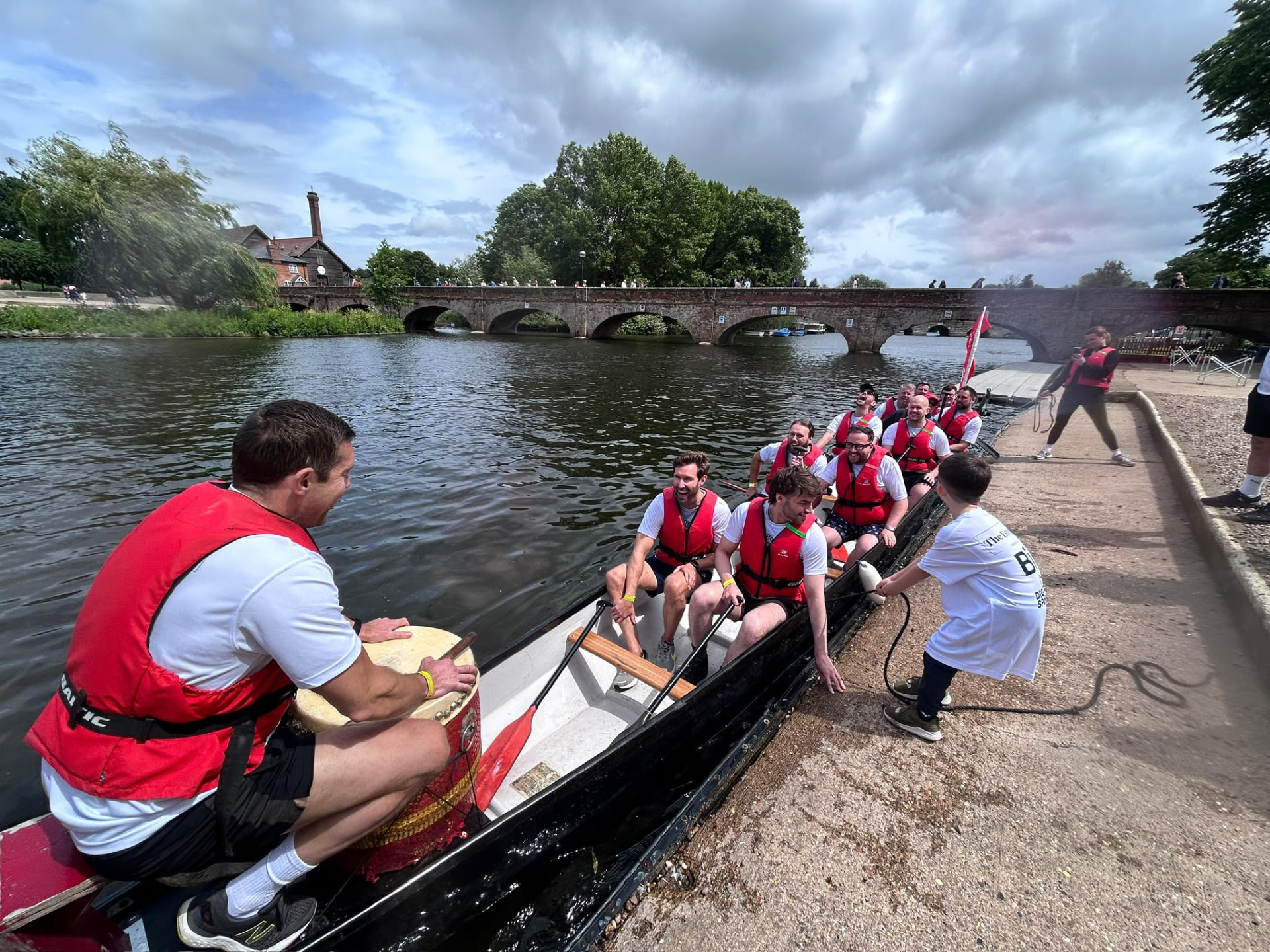 The crew laughing together in the dragon boat before setting off